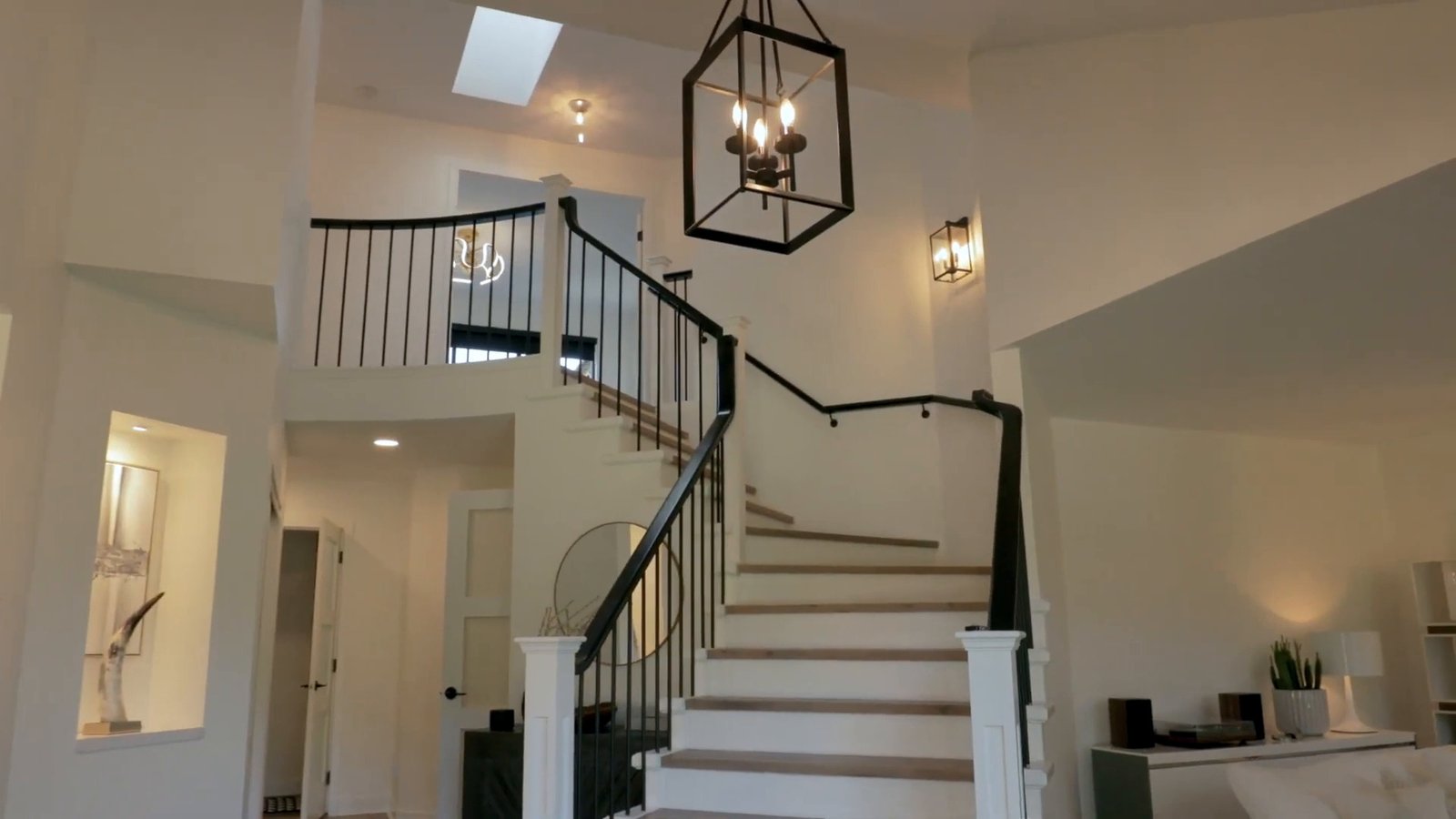 Curved staircase with crystal chandelier at 1276 Haywood Avenue, West Vancouver — DELANA Interiors