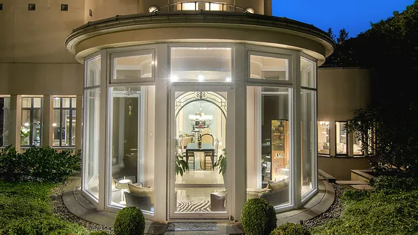 Curved glass conservatory exterior at dusk, 1561 Inglewood Avenue, West Vancouver — DELANA Interiors