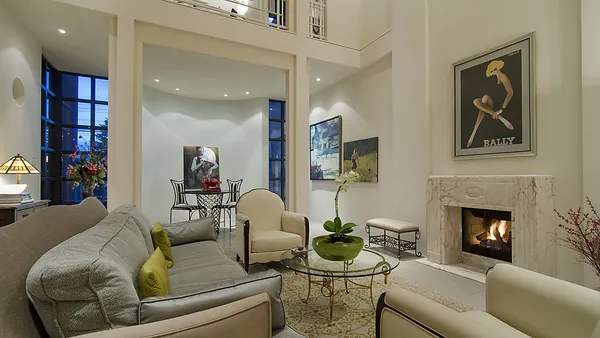 Living room with marble fireplace surround and Art Deco Bally poster at 1561 Inglewood Avenue, West Vancouver — DELANA Interiors