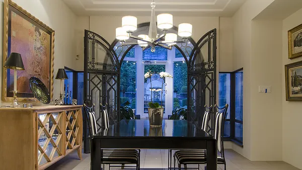 Dining room through double wrought-iron archway at 1561 Inglewood Avenue, West Vancouver — DELANA Interiors
