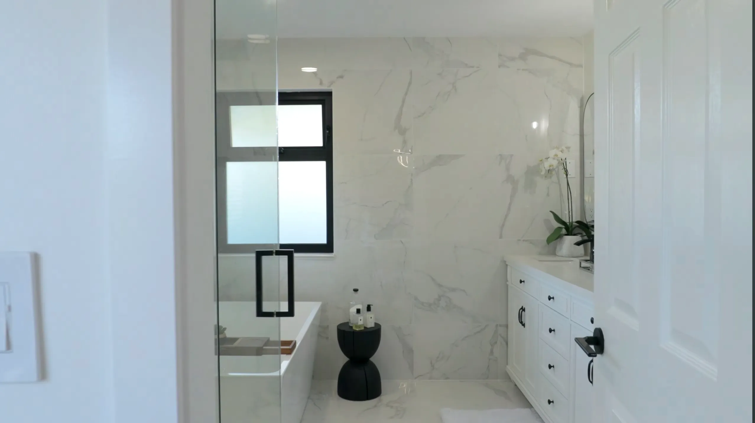 Bathroom renovation West Vancouver — 1588 Pinecrest Drive primary ensuite with freestanding soaker tub and full-height tile by DELANA Interiors