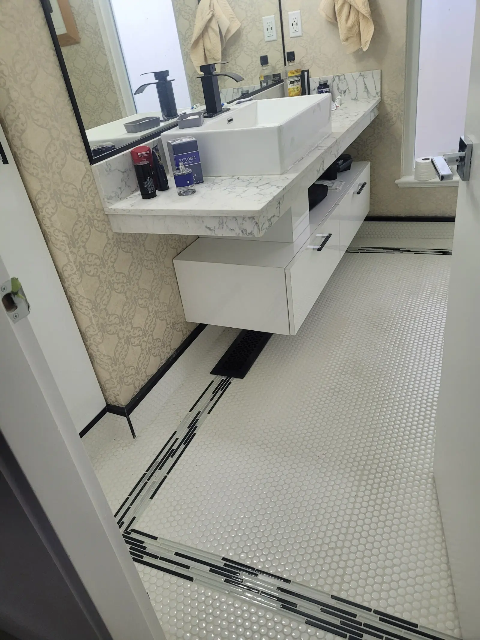 Floating bathroom vanity with marble countertop, mosaic penny tile floor and matte black fixtures — bathroom renovation Vancouver