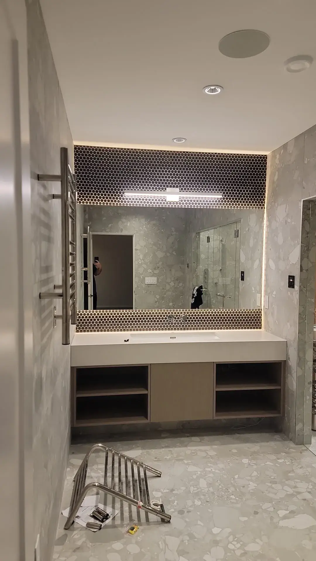 Modern bathroom with backlit hexagon tile mirror surround, open shelving cabinet and terrazzo flooring — bathroom renovation Vancouver