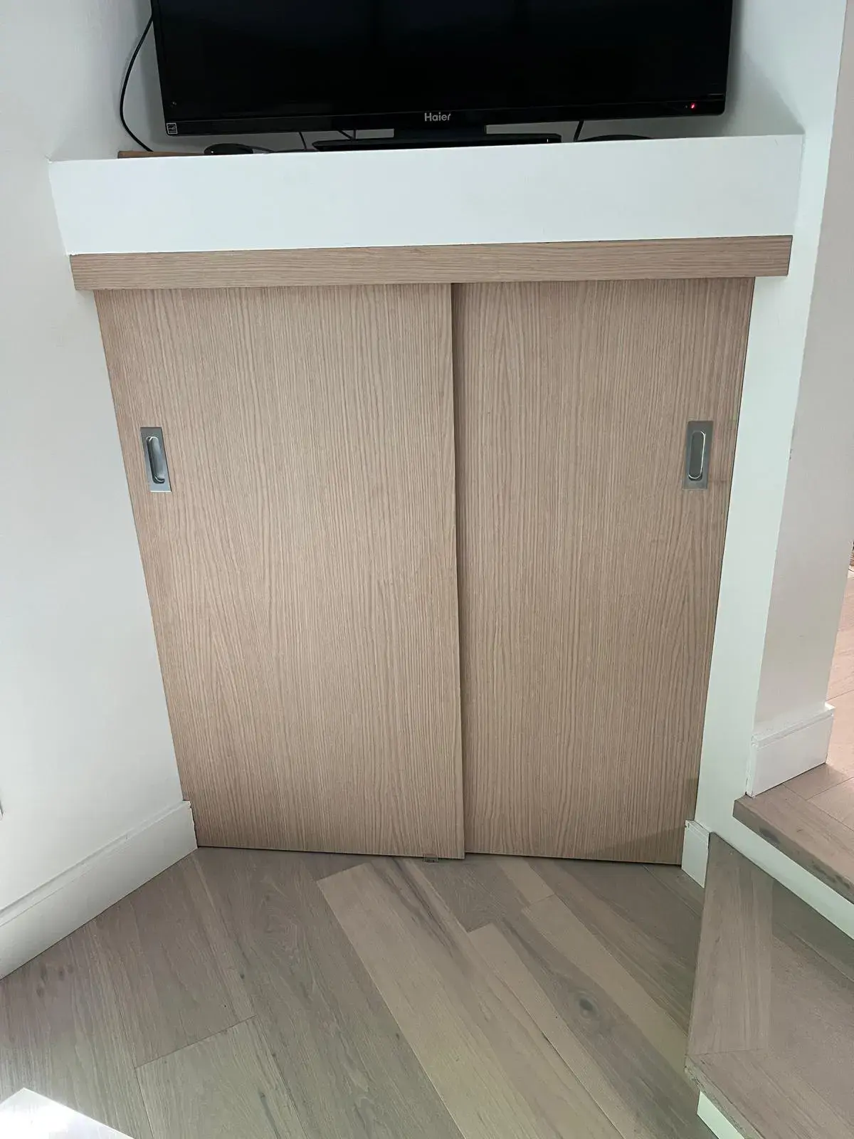 Custom oak sliding storage cabinet with integrated TV alcove and built-in shelving — custom millwork Vancouver