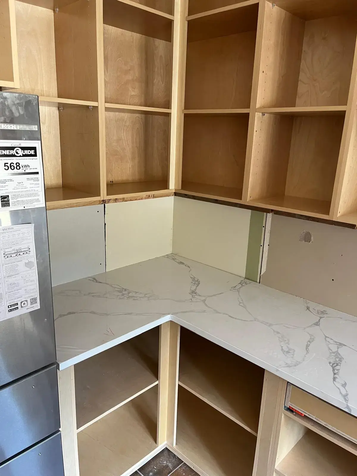Custom kitchen cabinetry and Calacatta quartz countertop under installation — kitchen renovation Vancouver
